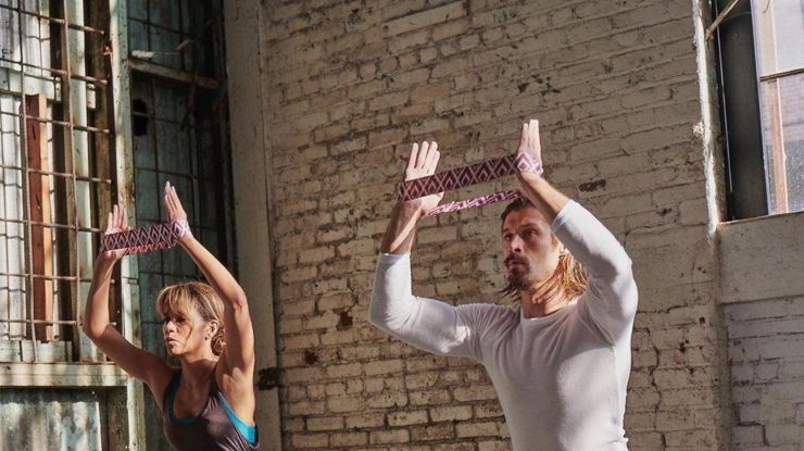 O femeie și un bărbat care fac sport într-o sală de fitness.