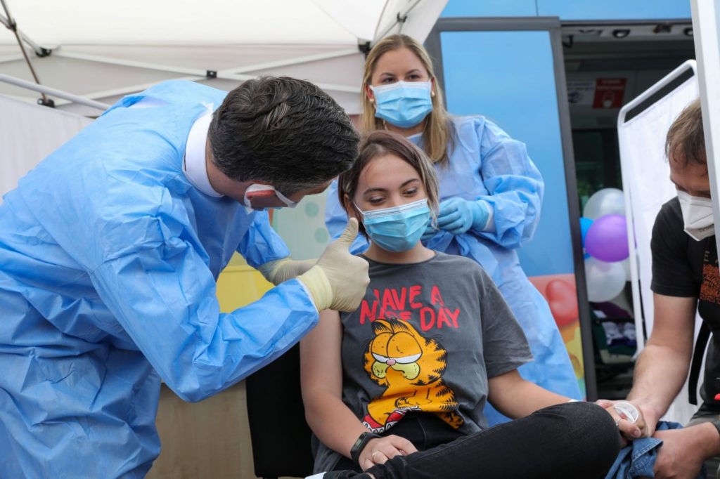 Valeriu Gheorghiță salută o tânără după vaccinarea anti-COVID.