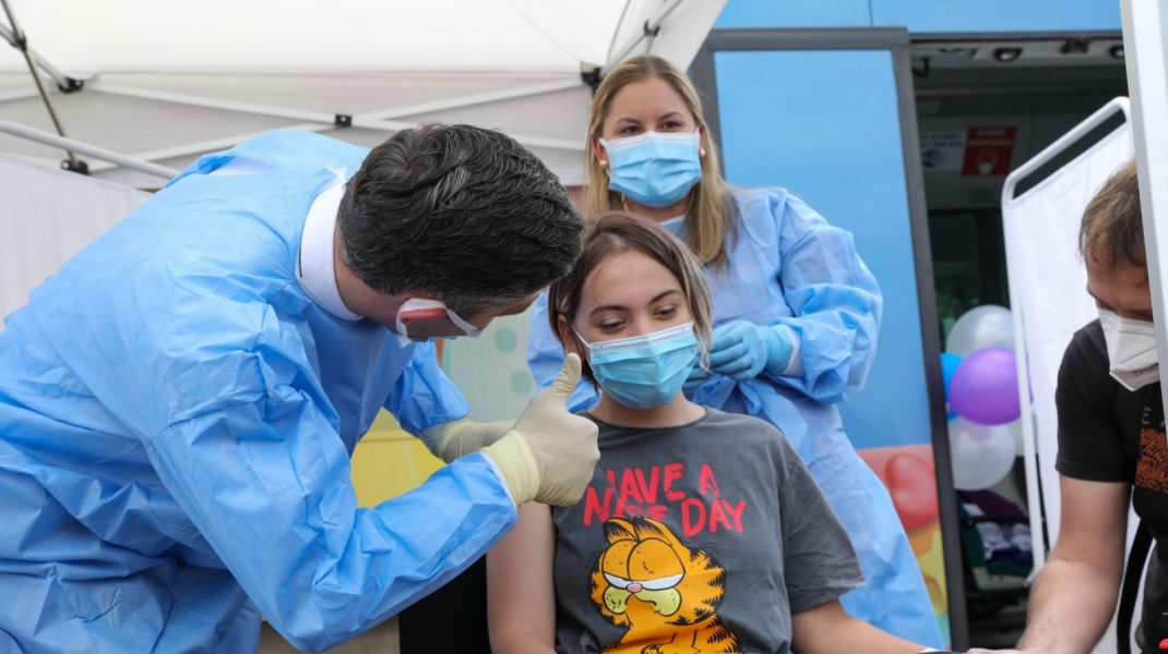 Valeriu Gheorghiță salută o tânără după vaccinarea anti-COVID.