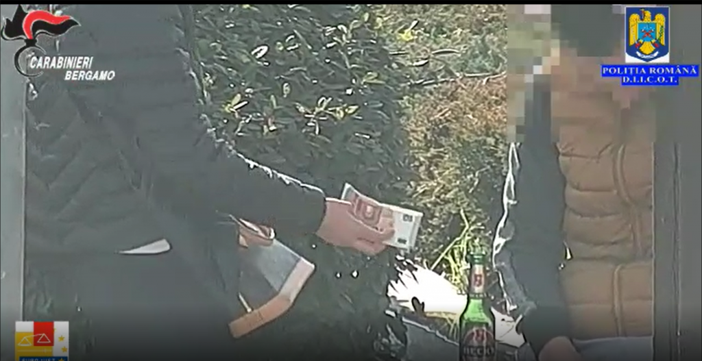 O fată obligată să se prostitueze, filmată când îi dă bani unuia dintre proxeneți. Foto: DIICOT