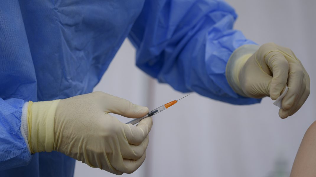 Medic su seringă de vaccin în mână.