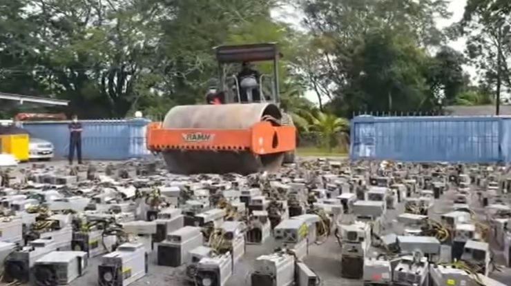 VIDEO. Momentul în care polițiștii din Malaezia distrug mii de platforme miniere bitcoin cu ajutorul unui compactor