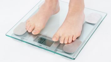 Femeie care stă pe cântar.