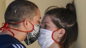 Cuplu care se sărută cu mască.
