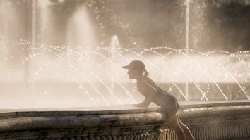 Fetiță care stă lângă fântână în București.