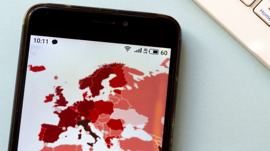 harta europei cu cazurile de covid, vazuta pe un telefon.