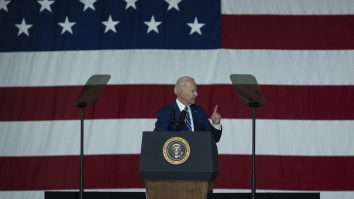 Joe Biden cu drapelul SUA în spate.