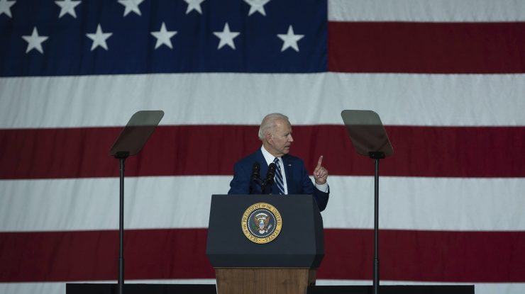 Joe Biden cu drapelul SUA în spate.