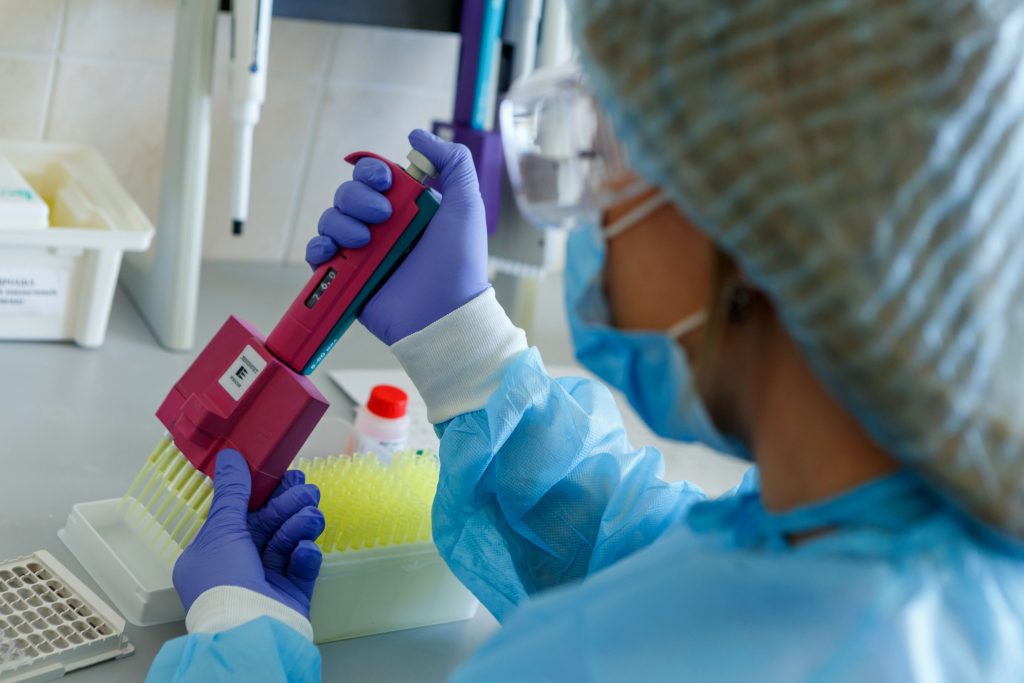 Medic care studiază virusul SARS-CoV-2 în laborator.