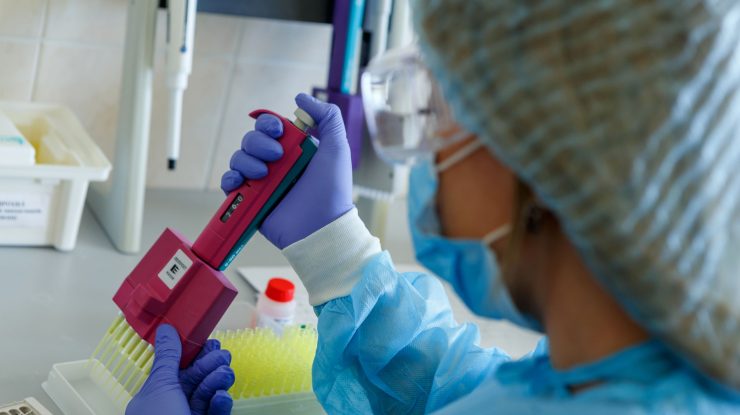 Medic care studiază virusul SARS-CoV-2 în laborator.