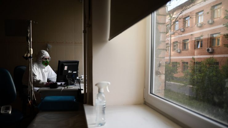 Medic care lucrează la laptop într-un salon de spital.