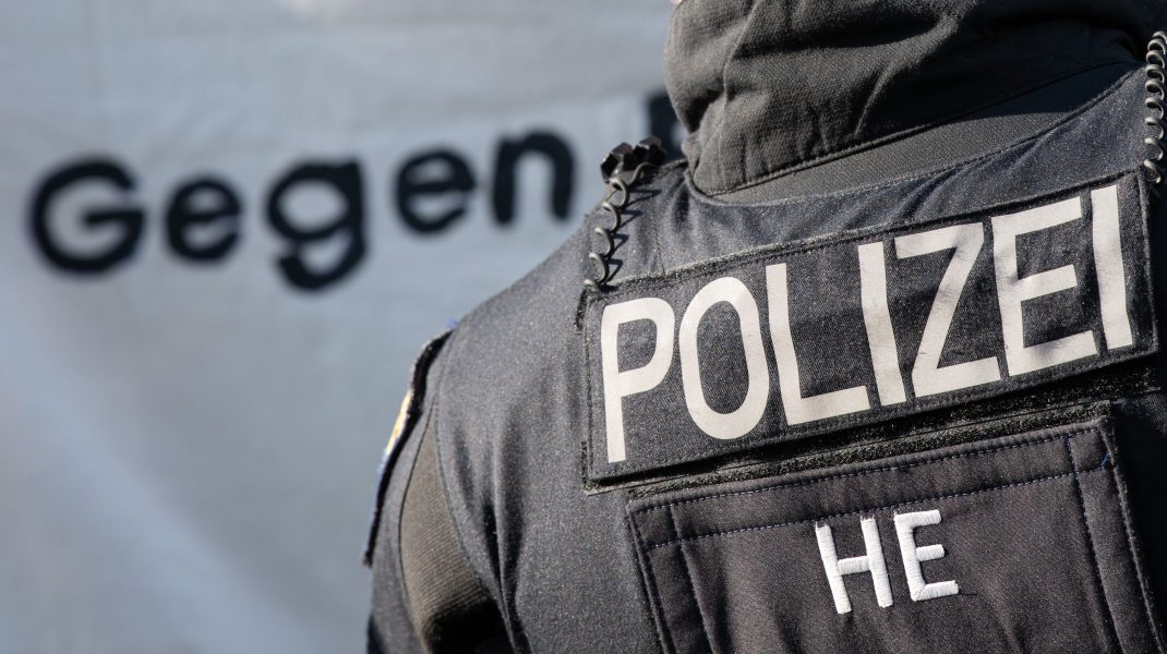 Polițist german care stă cu spatele.