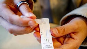 Test COVID-19 în mâinile unui bărbat.