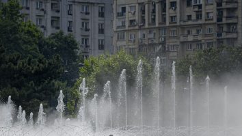 Doua tinere discuta langa fantanile din Piata Unirii, intr-o zi caniculara, in Bucuresti, sambata, 4 iulie 2020.