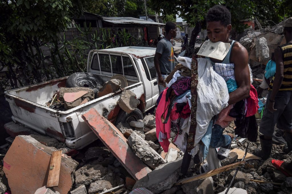 oameni printre ruine dupa cutremurul din haiti