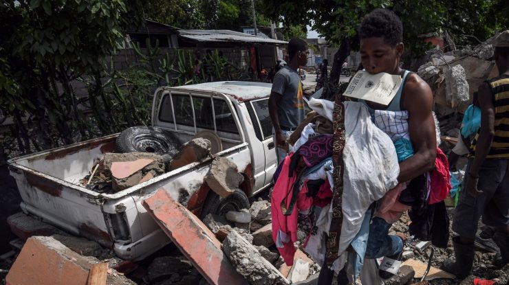 oameni printre ruine dupa cutremurul din haiti