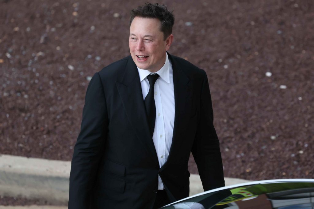 Elon Musk fotografiat lângă o mașină.