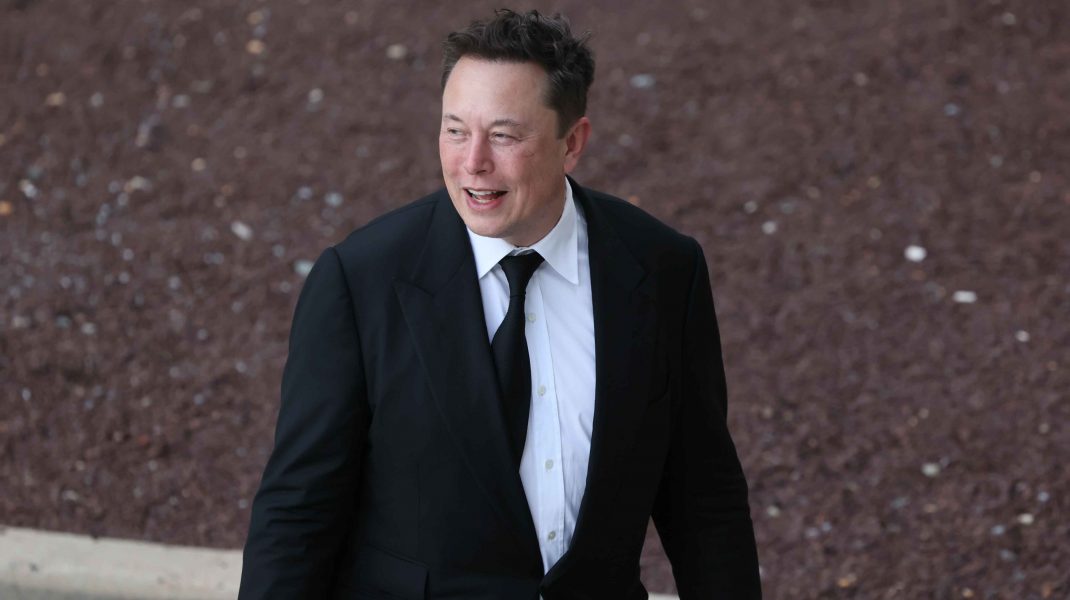 Elon Musk fotografiat lângă o mașină.