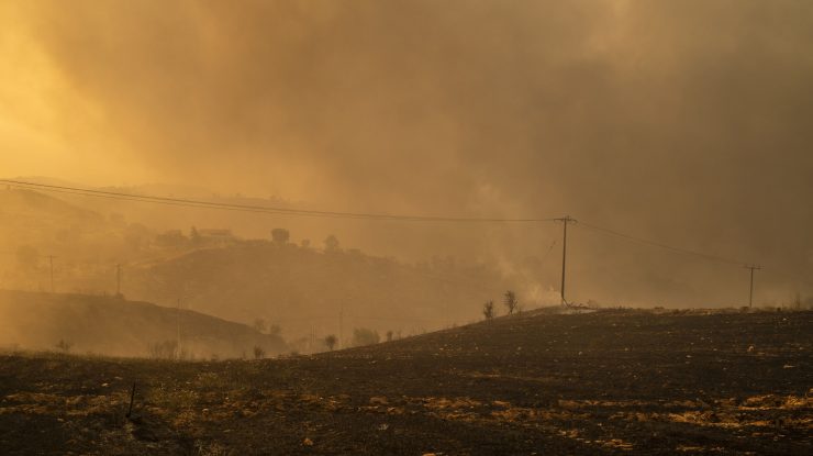06 august 2021, Grecia, Afidnes: Fumul se ridică din pământul ars într-o zonă împădurită la nord de Atena. Încă de la primele ore ale dimineții, vânturile puternice dinspre vest au continuat să alimenteze numeroasele incendii de vineri. Foto: Al: Angelos Tzortzinis/dpa