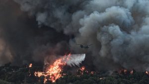 Un avion aruncă apă asupra unui incendiu de vegetație izbucnit într-o zonă forestieră din Tatoi, Grecia. Foto: Hepta