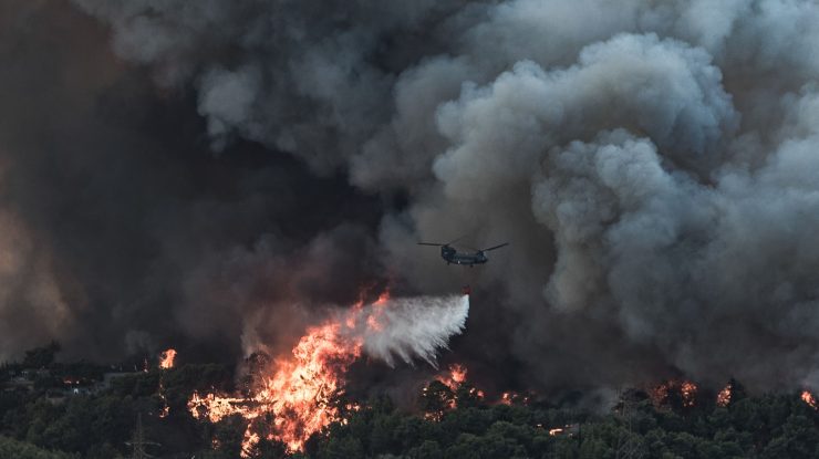 Un avion aruncă apă asupra unui incendiu de vegetație izbucnit într-o zonă forestieră din Tatoi, Grecia. Foto: Hepta