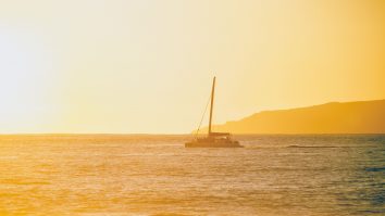 Vapor care merge pe apă la apus de soare.