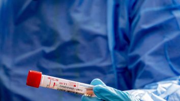 Medic care ține în mână o eprubetă de test COVID.