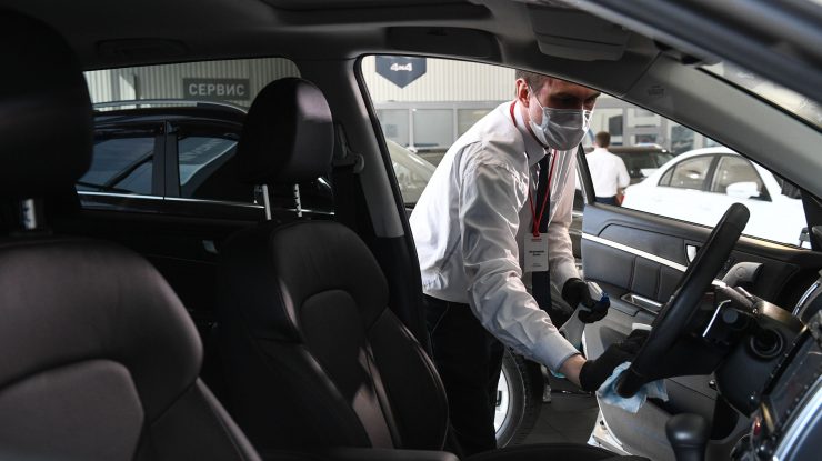 Angajat al unui showroom auto care face curat într-o mașină.