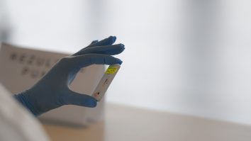 Asistentă care ține în mână un test de anticorpi COVID.