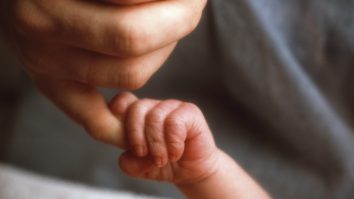 o femeie tine de mana un bebelus