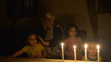 o femeie si copii pe intuneric, in liban, folosesc lumanari.