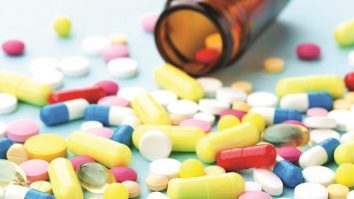 Colorful drug pills on blue background, pharmaceutical concept