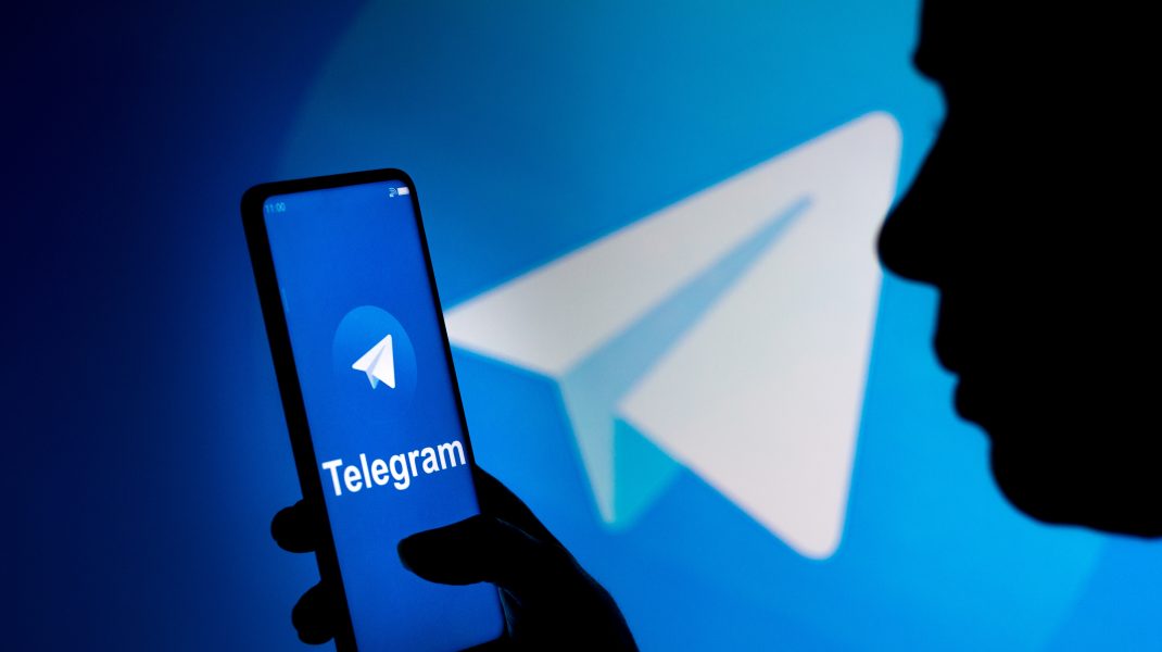 March 19, 2022, Brazil: In this photo illustration, a woman holds a smartphone with the Telegram logo displayed on the screen and on the background. (Credit Image: © Rafael Henrique/SOPA Images via ZUMA Press Wire)