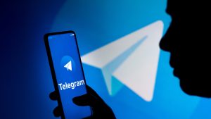 March 19, 2022, Brazil: In this photo illustration, a woman holds a smartphone with the Telegram logo displayed on the screen and on the background. (Credit Image: © Rafael Henrique/SOPA Images via ZUMA Press Wire)