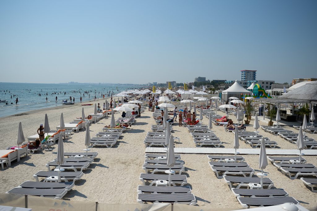 Persoane stau la plaja, in statiunea Mamaia, duminica, 10 august 2014. MARIUS DUMBRAVEANU /