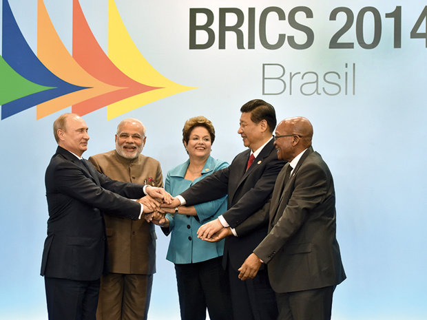 (L to R) Russia's President Vladimir Putin, India's Prime Minister Narendra Modi, Brazilian President Dilma Rousseff, China's President Xi Jinping and South Africa's President Jacob Zuma join their hands during the official photograph of the 6th BRICS summit in Fortaleza, Brazil, on July 15, 2014. Leaders of the BRICS (Brazil, Russia, India, China and South Africa) group of emerging powers gathered in Brazil on Tuesday to launch a new development bank and a reserve fund seen as counterweights to Western-led financial institutions. AFP PHOTO / NELSON ALMEIDA