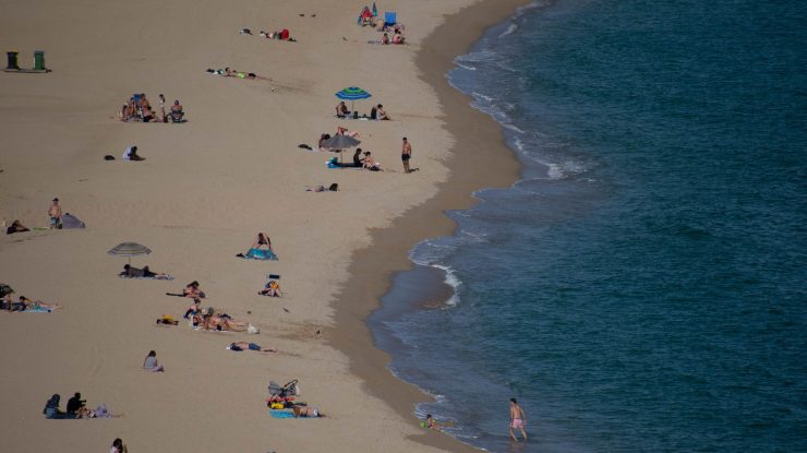 30 May 2022, Spain, Barcelona: People sit on the beach of Arenys de Mar. Photo: Matias Basualdo/ZUMA Press Wire/dpa