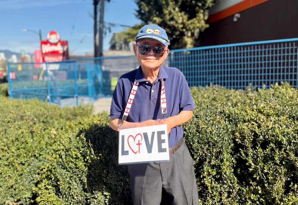 Un bărbat de 88 ani poartă la gât o pancartă cu cuvântul „LOVE”. John Shin este din Vancouver și face asta zilnic