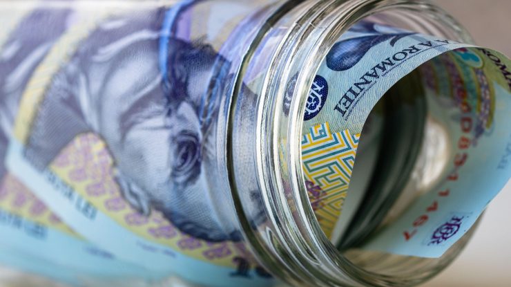 Composition with saving money romanian LEI banknotes in a glass jar. Concept of investing and keeping money, close up isolated.