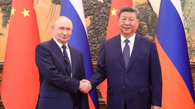 Chinese President Xi Jinping shakes hands with Russian President Vladimir Putin at the Great Hall of the People, in Beijing